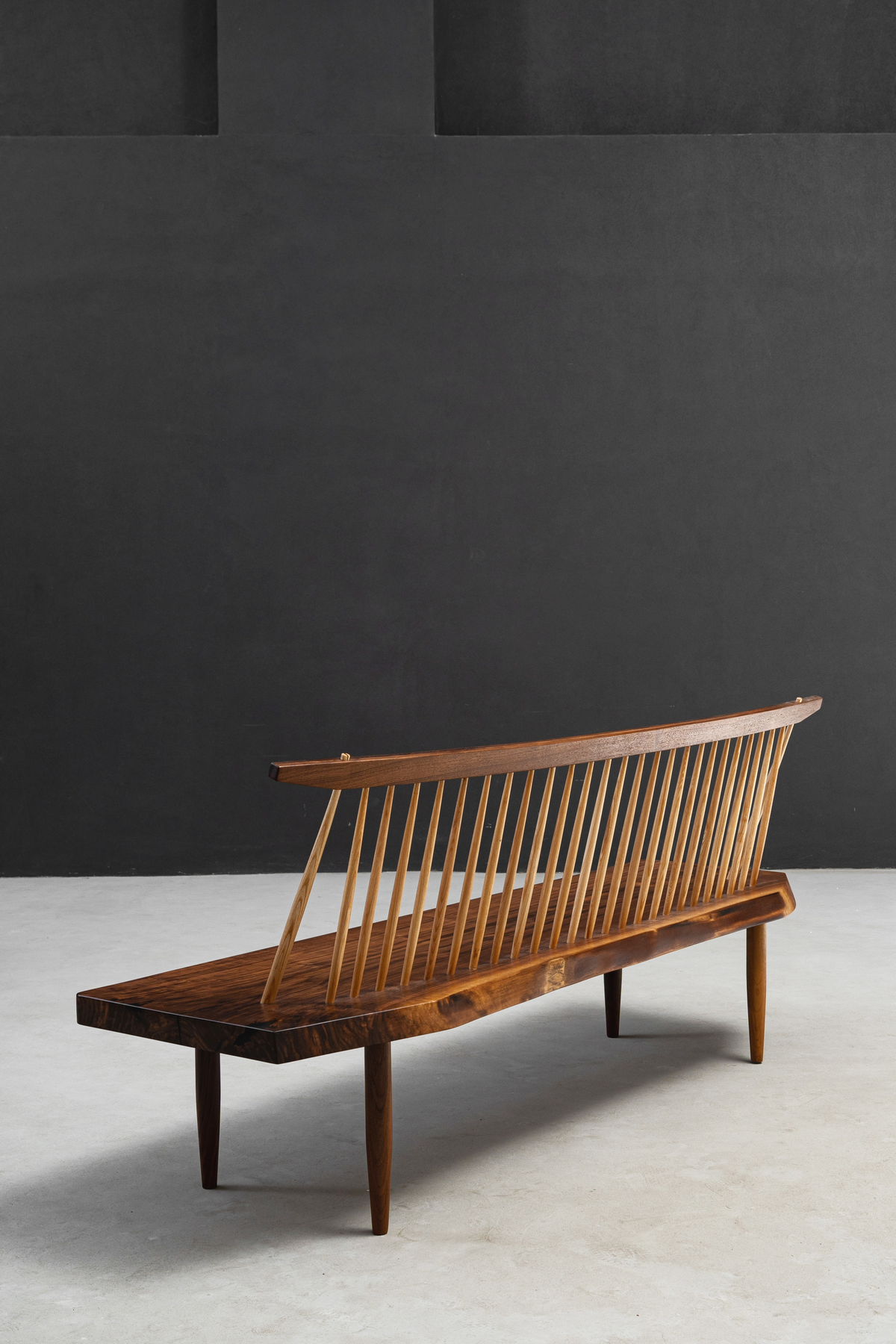 Side-back perspective of String Theory Bench showing spindle joinery and seat construction.