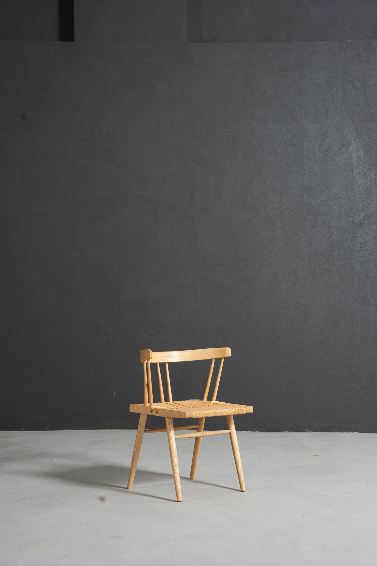 Angled side perspective of Symphony Chair highlighting ash wood joinery and elegant form.