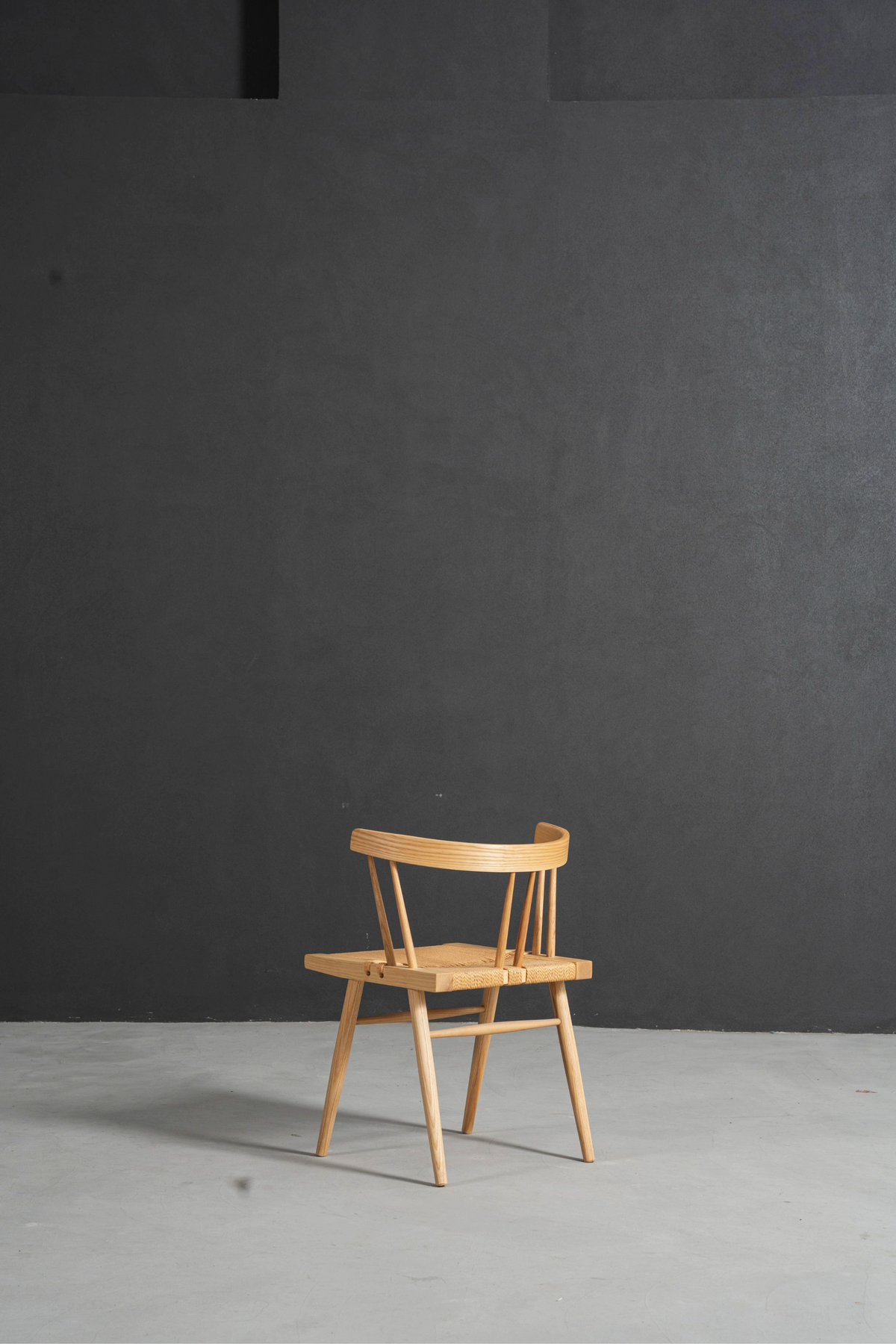 Side-rear angle revealing master craftsmanship in chair's frame and joinery.