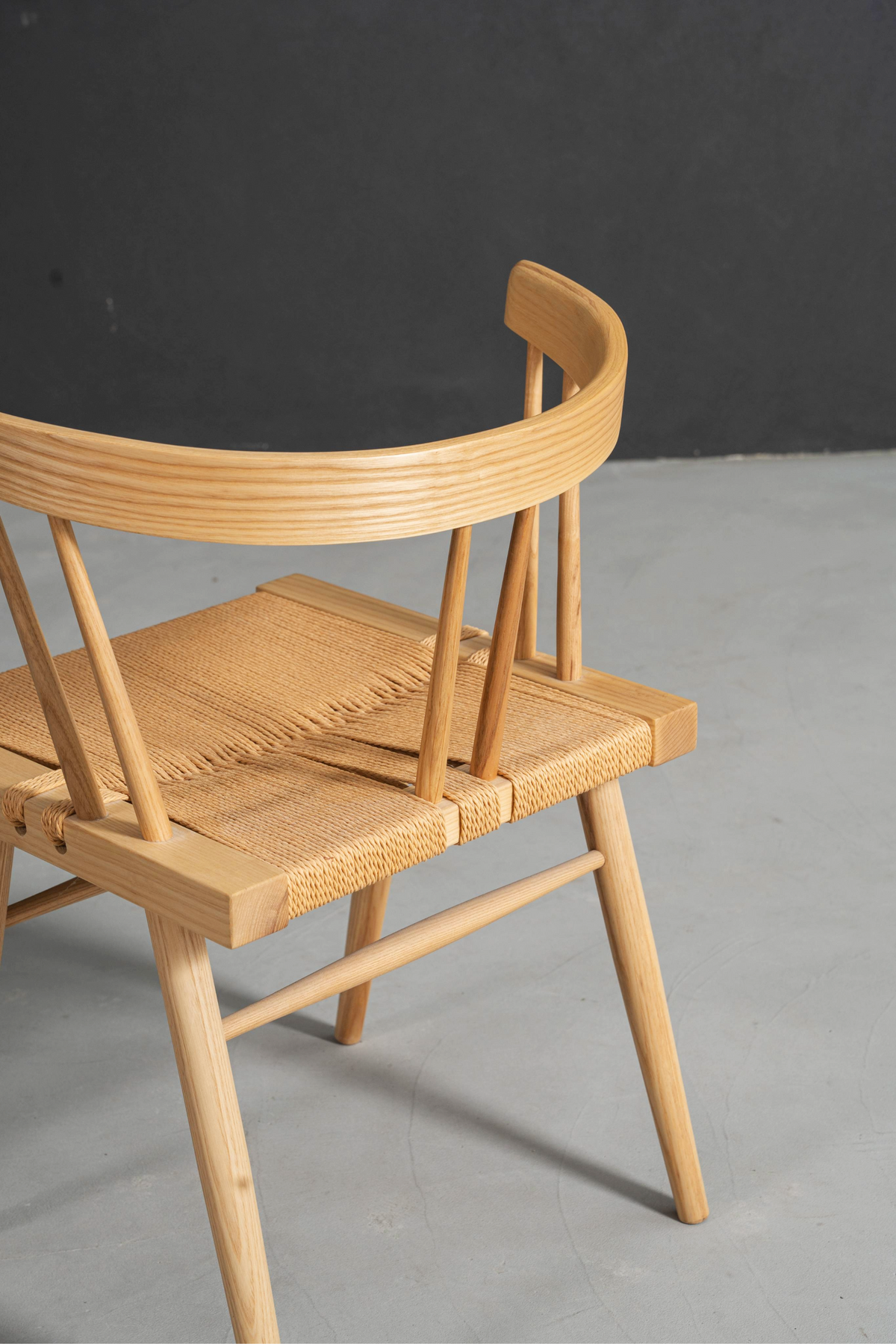 Detailed view showing textured jute weaving integrated with smooth ash wood joinery.
