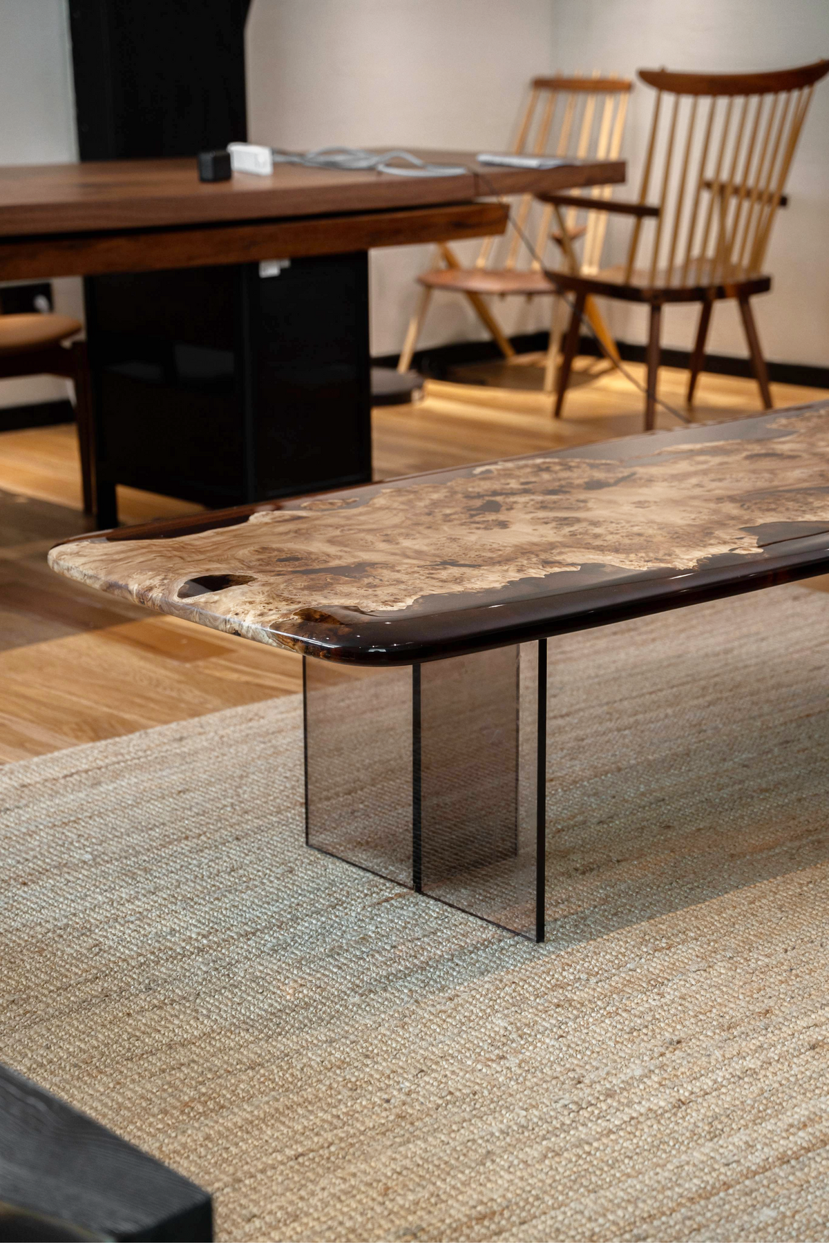 Lifestyle shot showing the Synthesis Table's French Poplar wood slab supported by its acrylic base.