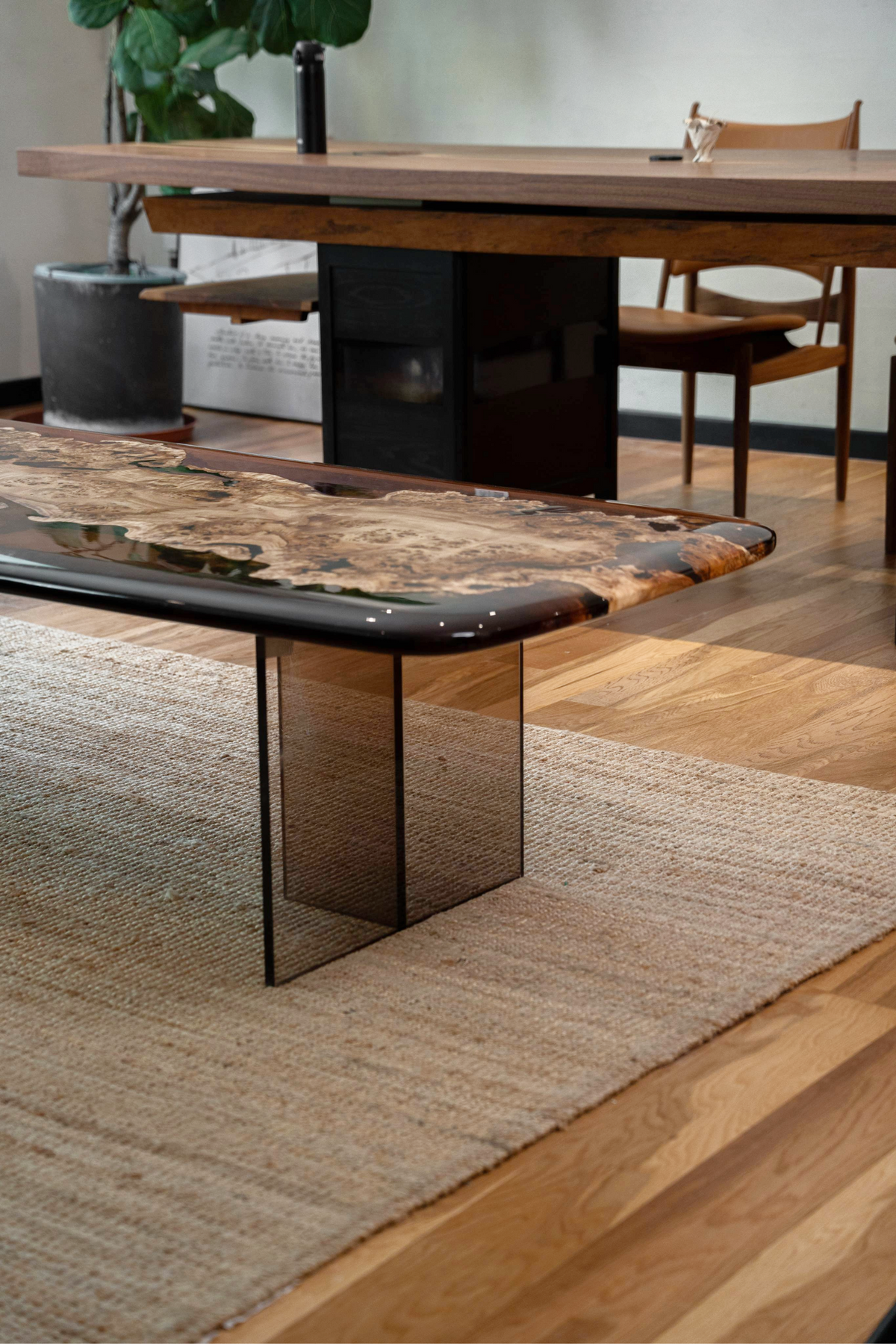 The Synthesis Table in a furnished interior, demonstrating its coffee table height and minimalist acrylic base.