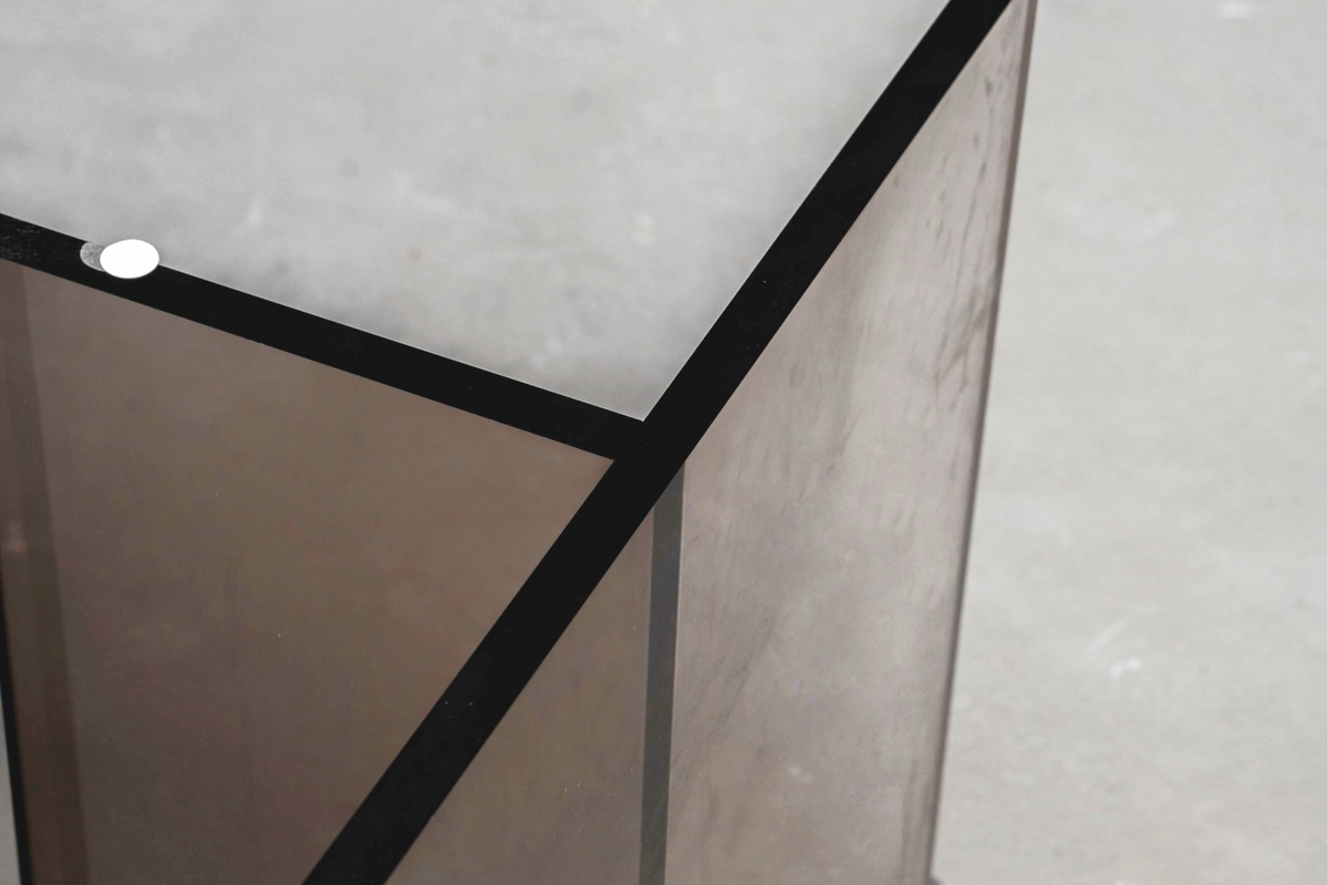 Close-up of the Whispering T base, showcasing its earth tone acrylic and minimalist design.
