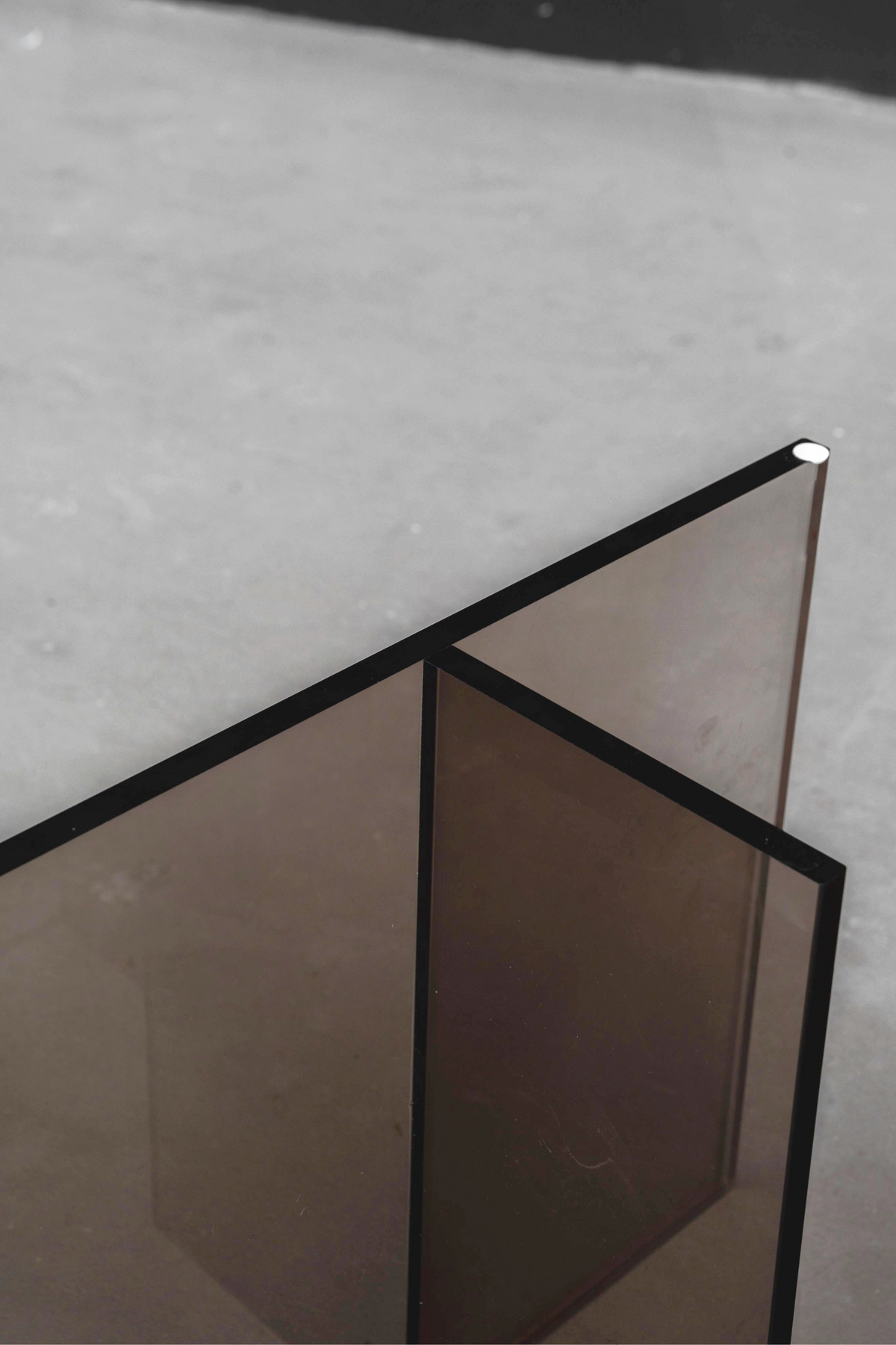 Close-up angled view of the Whispering T base's earth tone top section, showing its semi-transparent acrylic form.