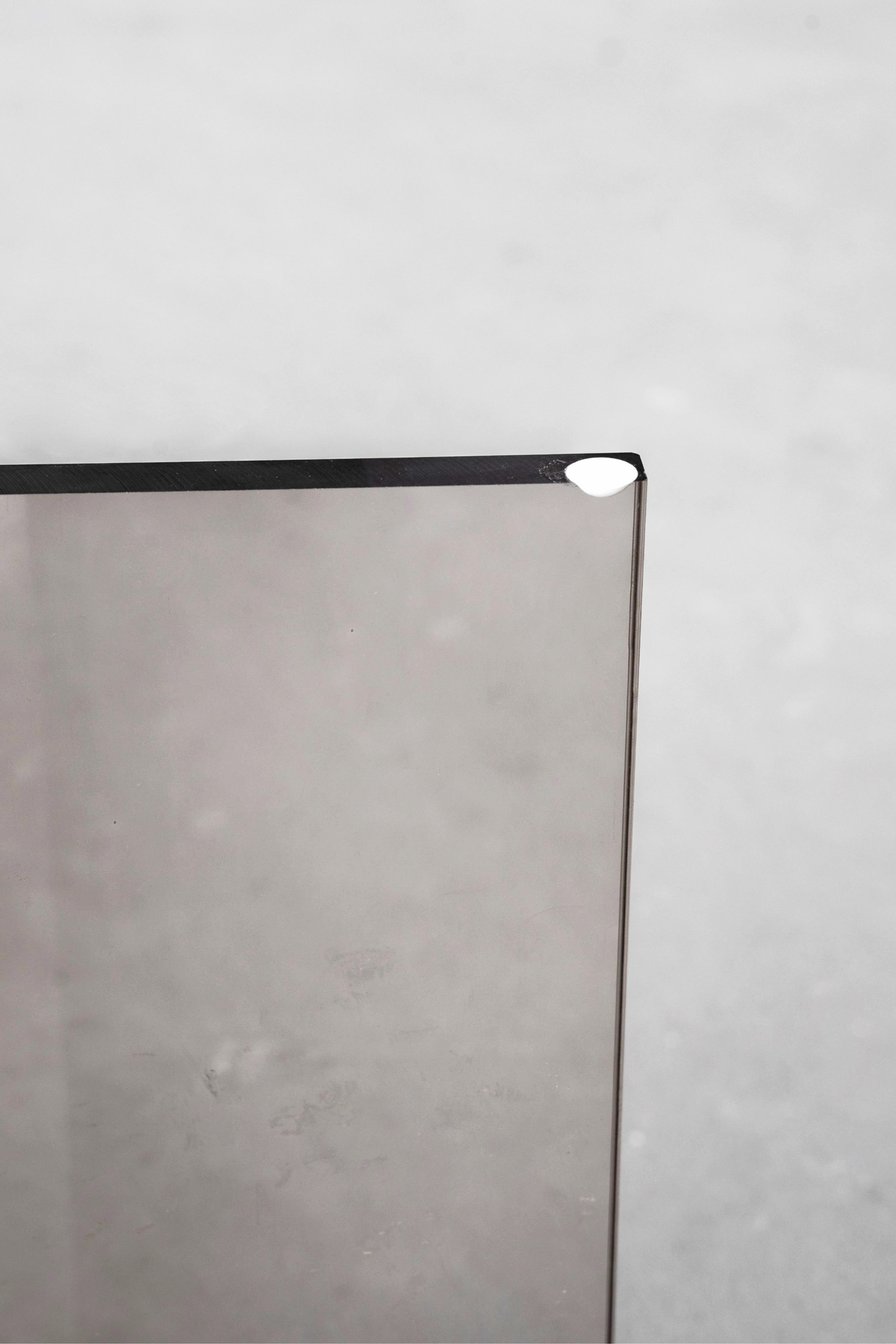 Macro view of the Whispering T's corner, emphasizing the elegant earth tone acrylic and minimalist form.