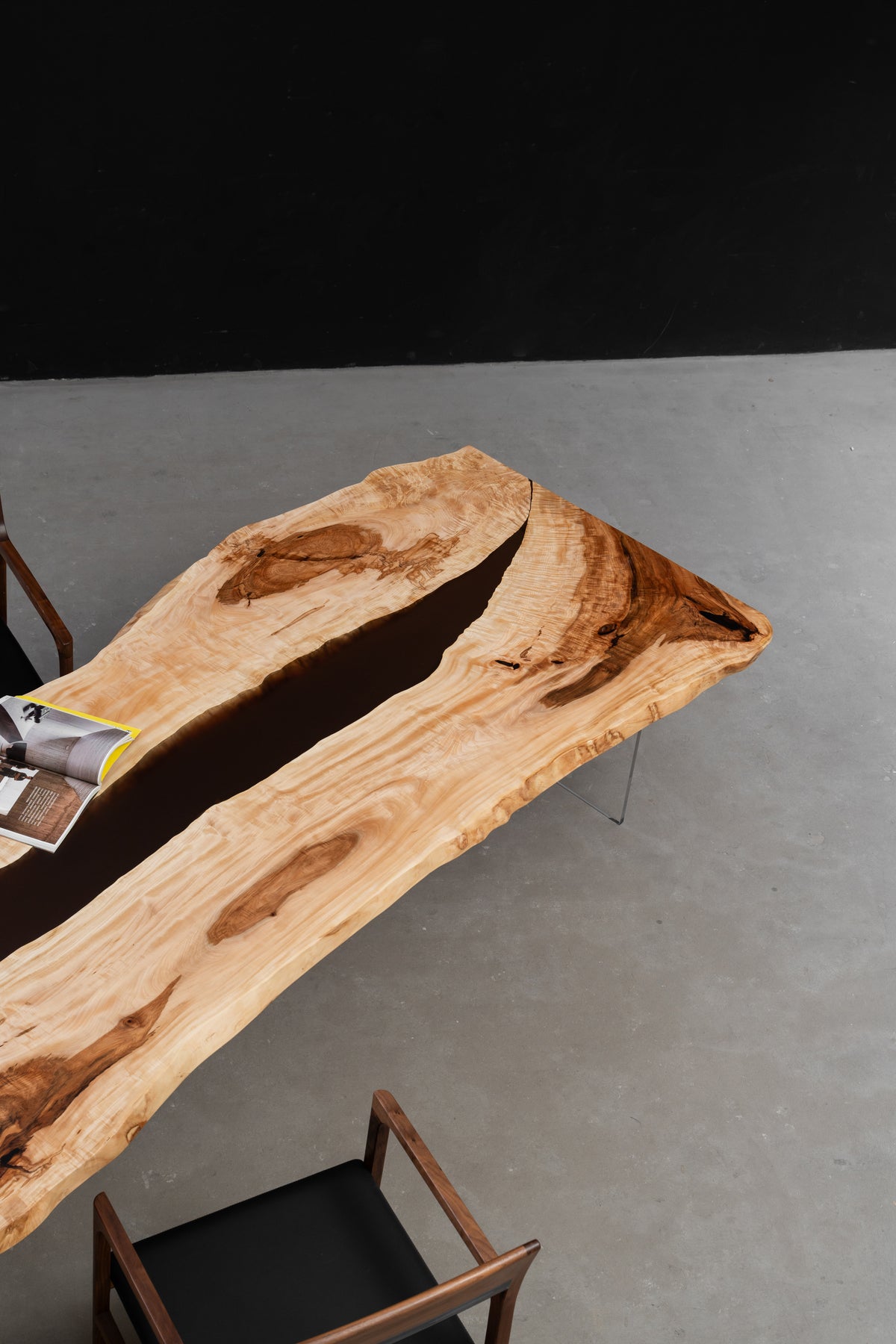 Three-quarter view of the Tochi Horizon dining table, showcasing Japanese horse chestnut grain, live-edge contours, and central resin river