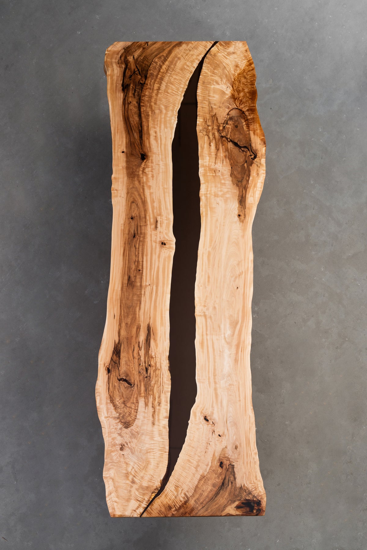 Underside view of Tochi Horizon live-edge table showing solid slab construction and structural integrity.