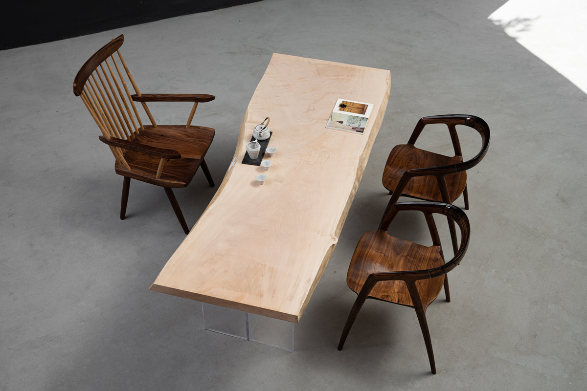 Wide lifestyle shot of the Tochi Veil live-edge table with designer chairs, focusing on material honesty 