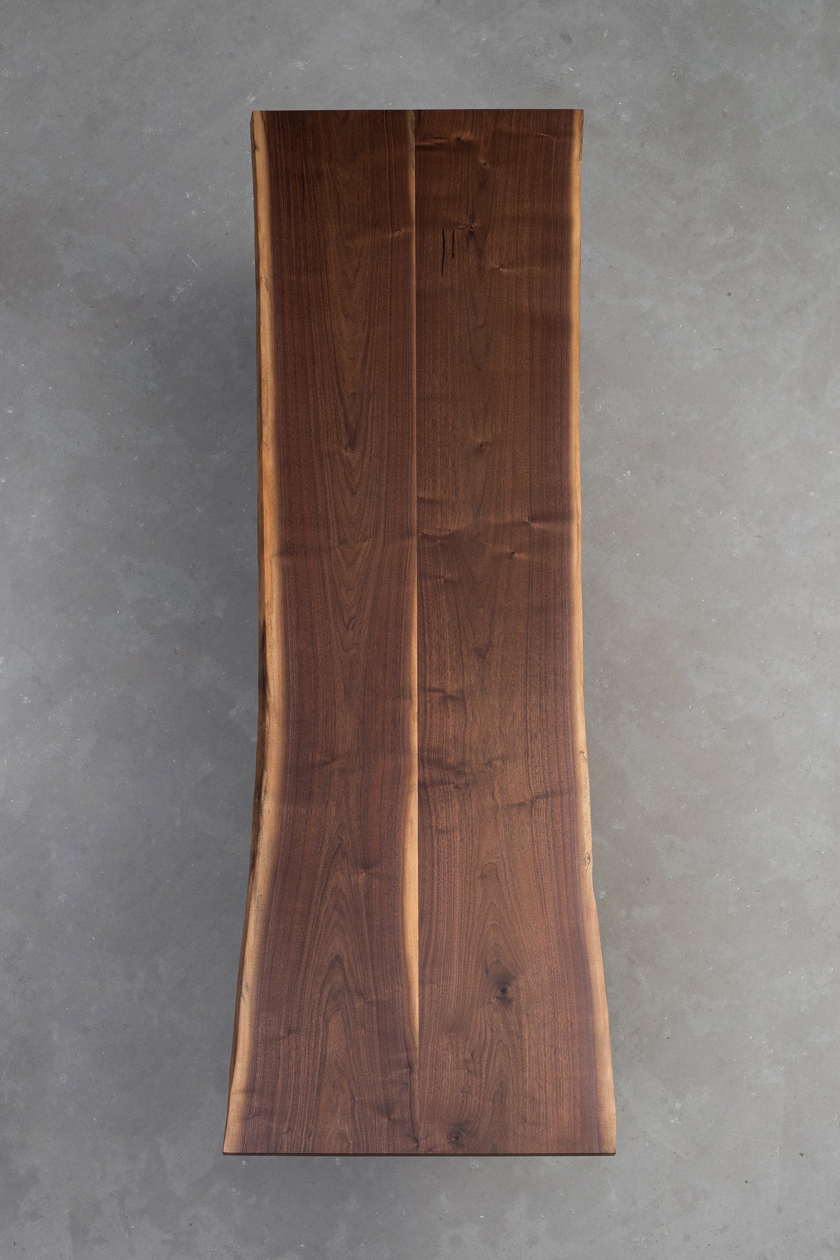 Full-length overhead view of the table underside, showcasing the black walnut grain and immense length of the slab
