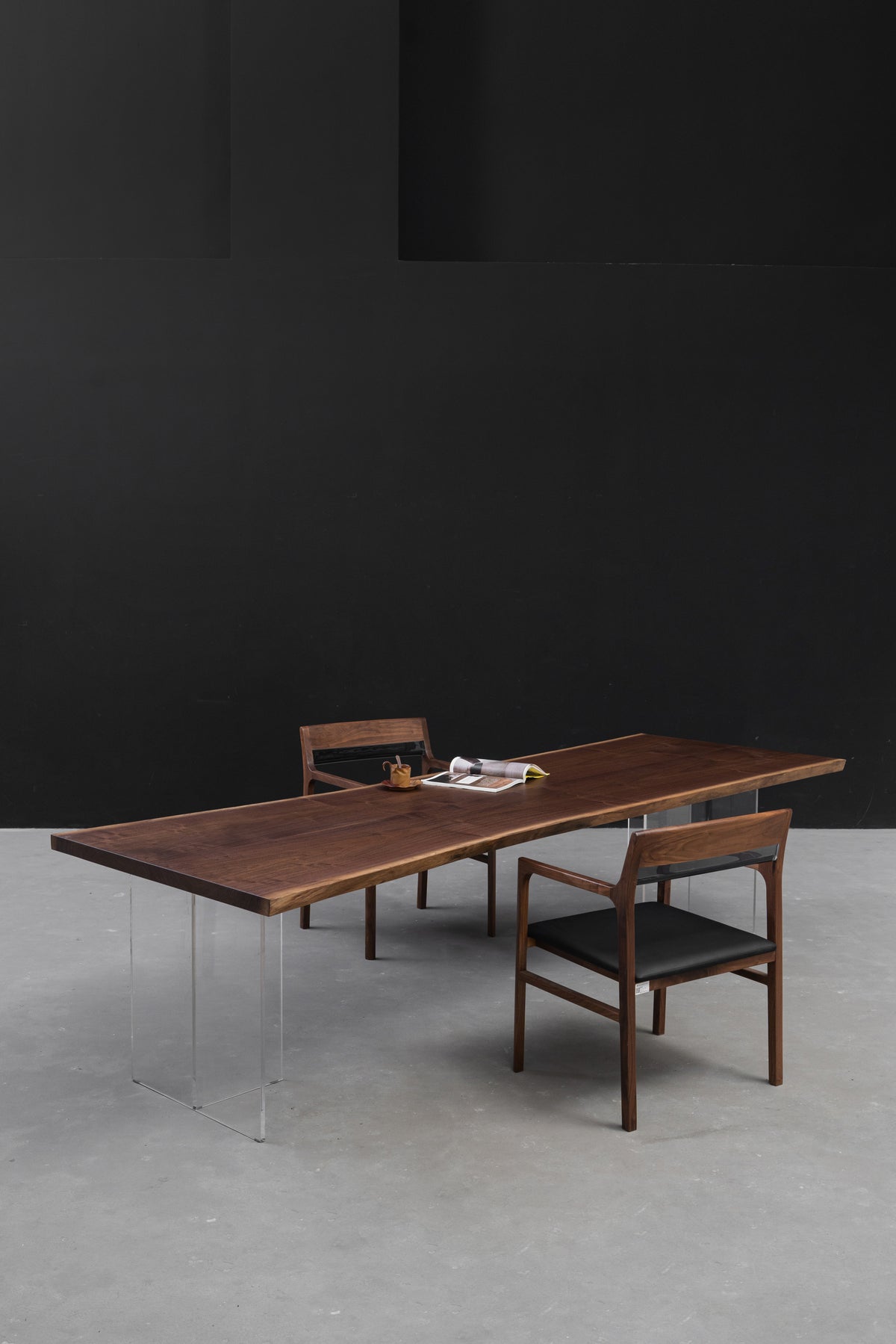 Duskwood Frontier live edge dining table in solid black walnut, photographed in a minimalist interior setting with architectural lines.