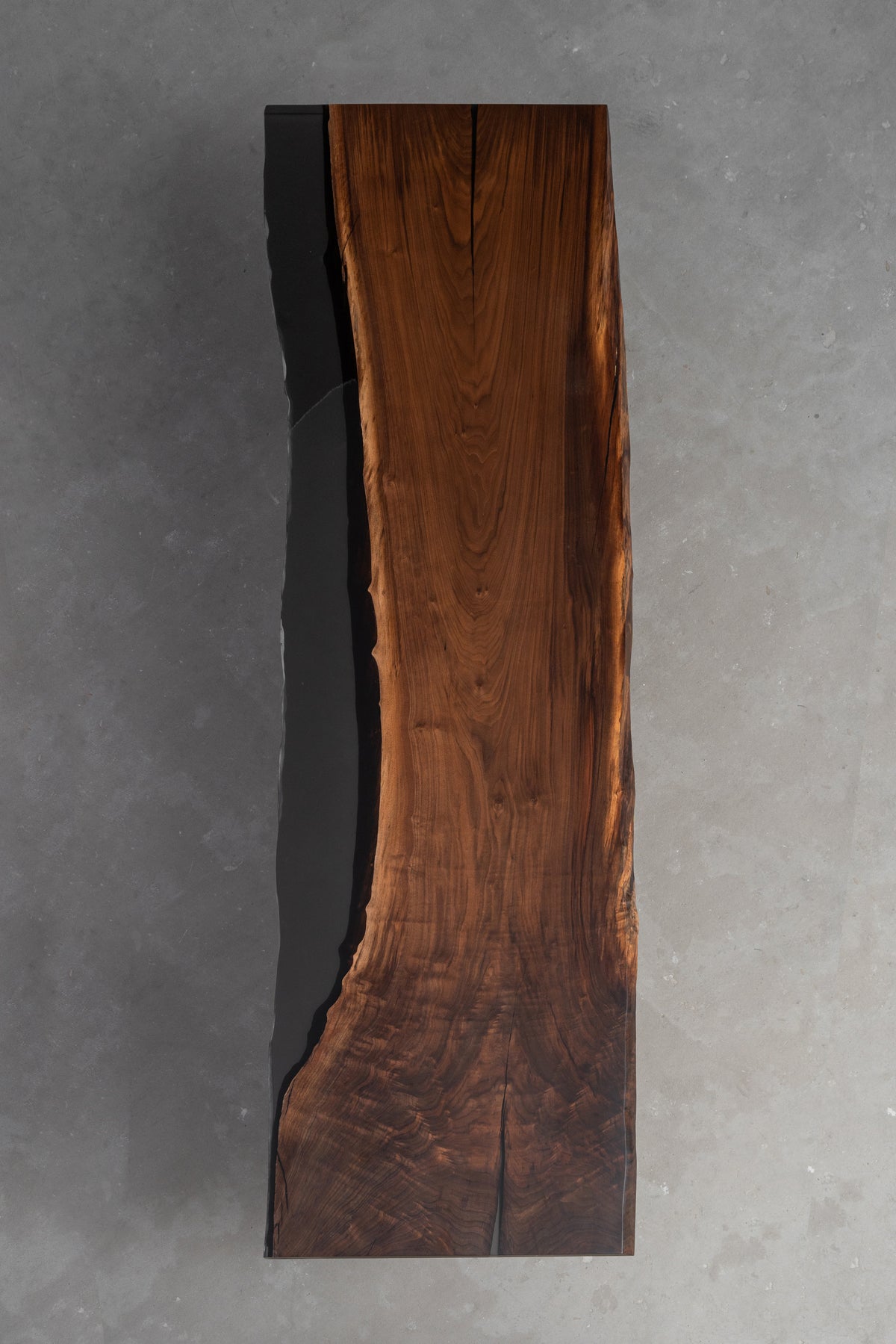 Duskwood Midnight sculptural wood table featuring a dark refined surface, strong linear form, and architectural presence